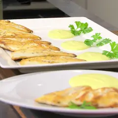 Pescado dorado a la plancha con salsa cremosa y perejil fresco. Un plato ligero y sabroso.